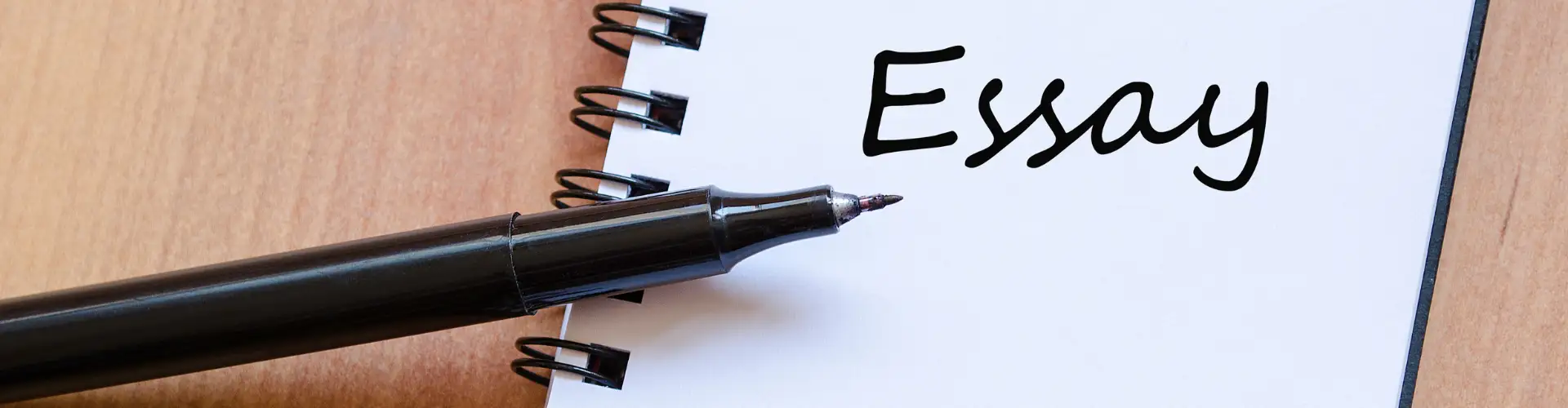Student revising a printed essay draft with editor comments in the margins